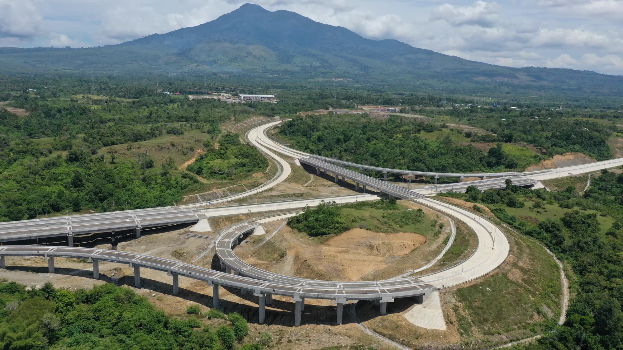 Simpang susun Jalan Tol Pekanbaru–Dumai dengan latar pegunungan